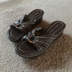 apostrophe. brown sandals. leather straps.